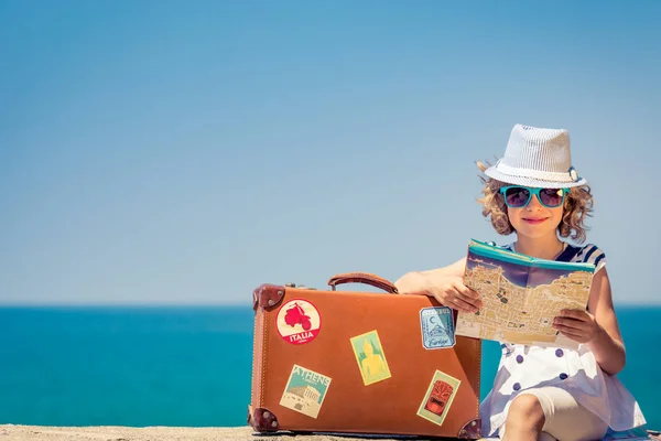 Ребенок с винтажным чемоданом на летних каникулах — стоковое фото