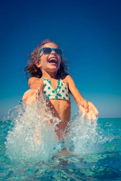 Счастливый ребенок, играющий в море — стоковое фото