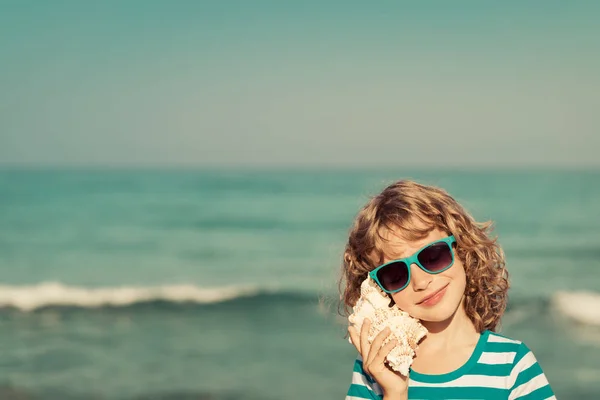 Heureux enfant écouter coquillage — Photo