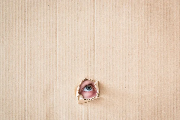 Ojo del niño mirando a través del agujero —  Fotos de Stock