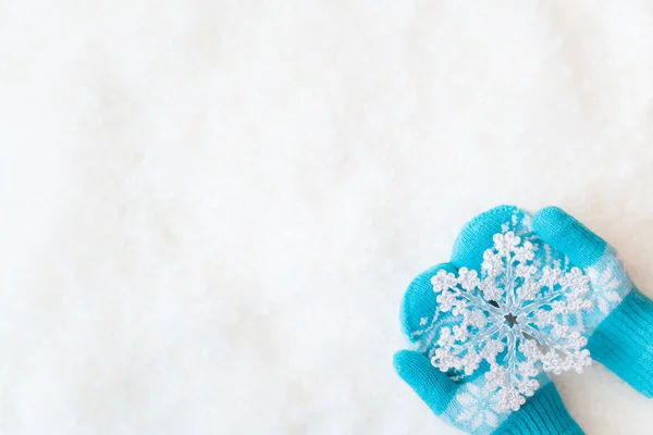 Hands in mittens holding decorative snowflake — Stock Photo, Image