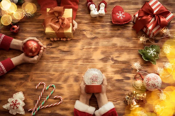 hands holding christmas tree decorations