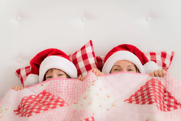 Mutter und Tochter in Hüten des Weihnachtsmanns — Stockfoto