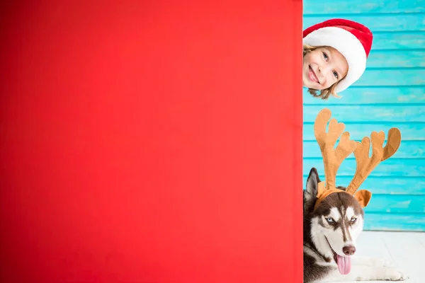Gelukkig kind en hond op kerstavond — Stockfoto