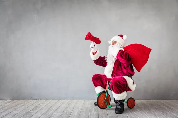 Santa Claus paardrijden speelgoed fiets — Stockfoto