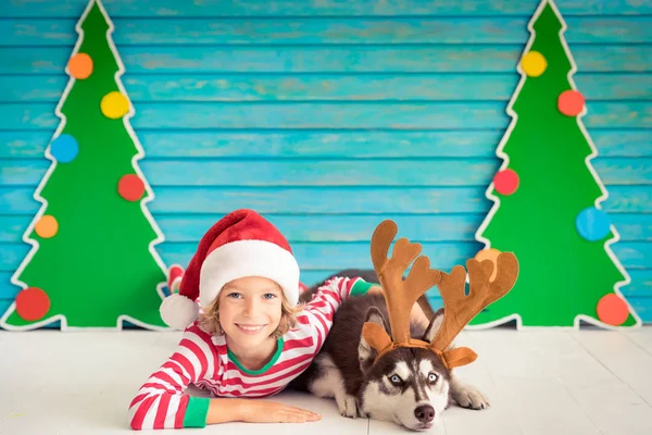 Criança feliz e cachorro na véspera de Natal — Fotografia de Stock