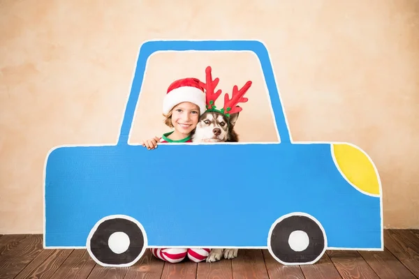 Onnellinen lapsi ja koira jouluaattona — kuvapankkivalokuva