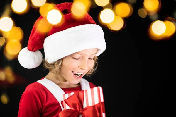 Surprised child holding Christmas gift box — Stock Photo, Image