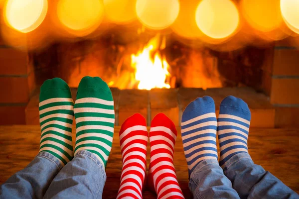 Familia en calcetines de Navidad cerca de la chimenea —  Fotos de Stock