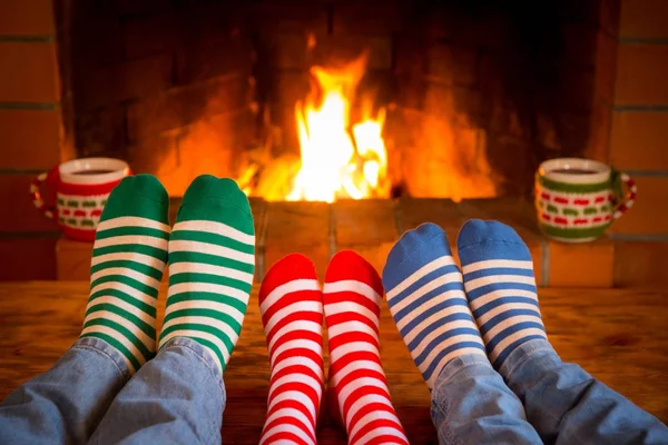 Familia en calcetines de Navidad cerca de la chimenea — Foto de Stock