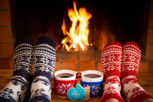 Couple in Christmas socks near fireplace