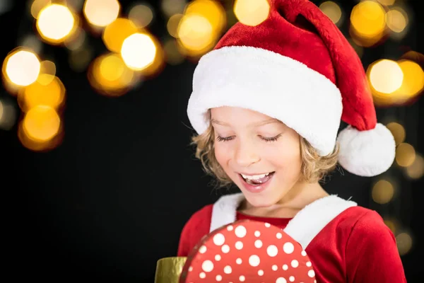 Criança surpresa segurando caixa de presente de Natal — Fotografia de Stock