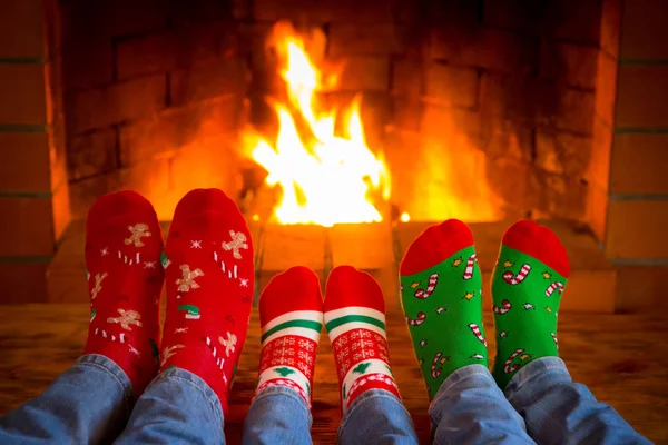 Сім'я в різдвяних шкарпетках біля каміна — стокове фото