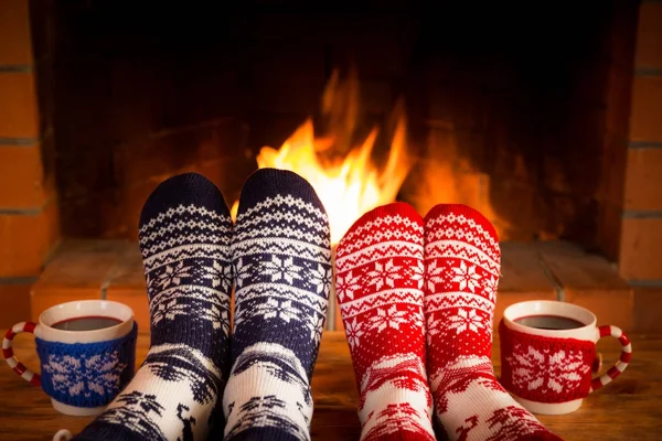 Casal em meias de Natal perto da lareira — Fotografia de Stock