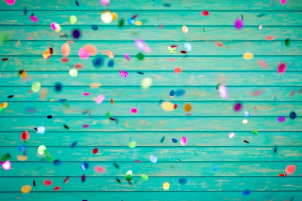 Confetti falling on wooden background — Stock Photo, Image