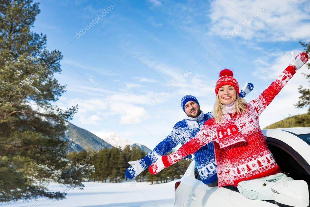 Happy couple travel by car in winter