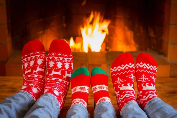 Семья в рождественских носках возле камина — стоковое фото