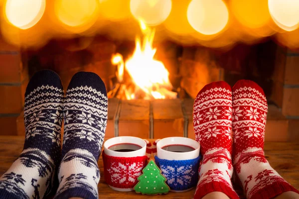 Casal em meias de Natal perto da lareira — Fotografia de Stock