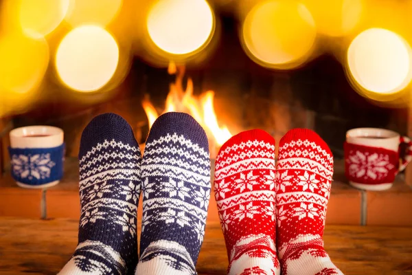 Casal em meias de Natal perto da lareira — Fotografia de Stock