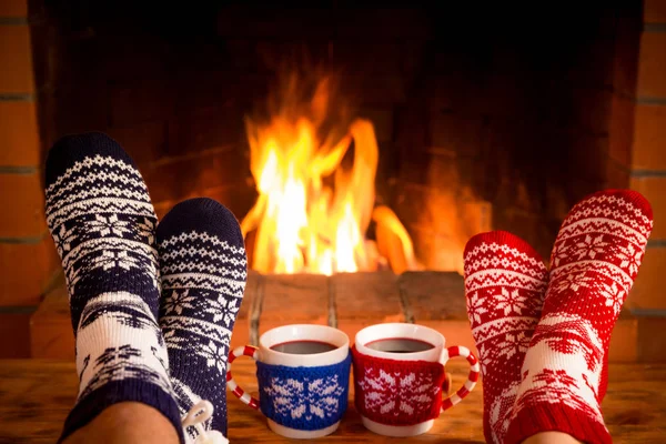 Couple in Christmas socks near fireplace — Stock Photo, Image