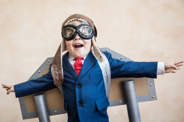 おもちゃの紙の翼を持つ若い実業家の肖像 — ストック写真