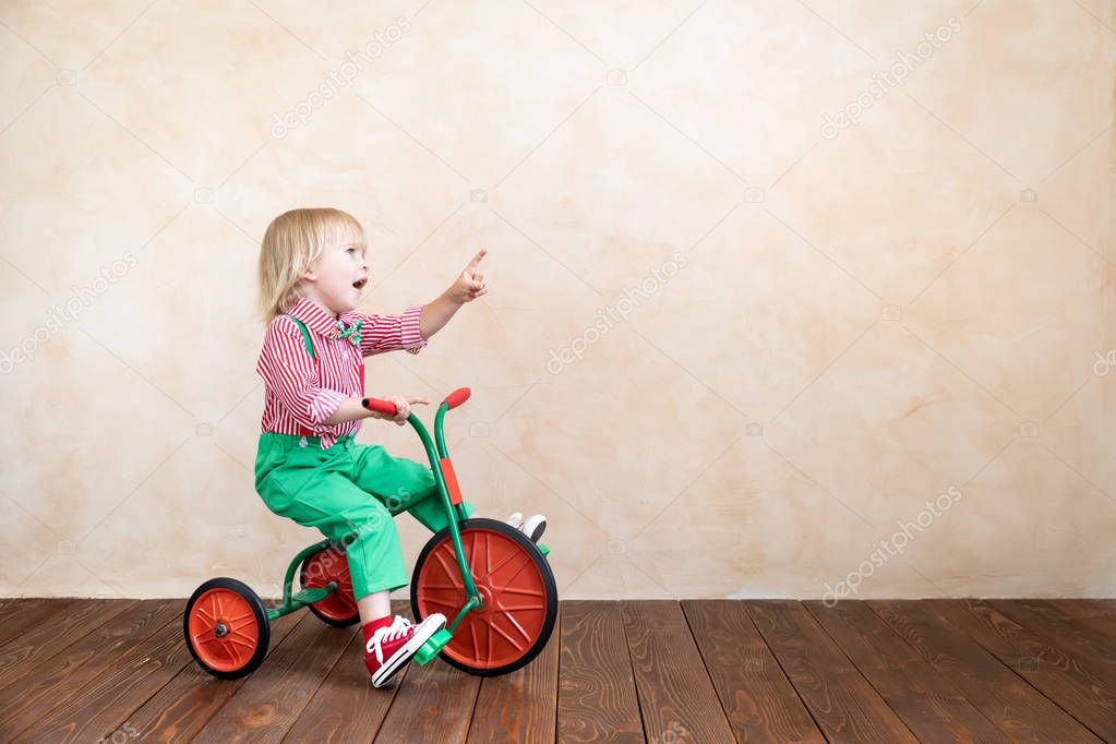 Happy child riding vintage tricycle