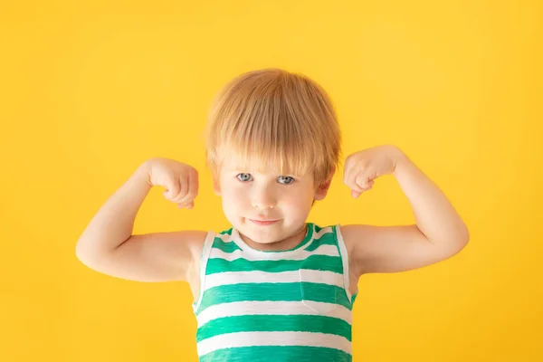 Šťastné dítě ukazující svaly — Stock fotografie