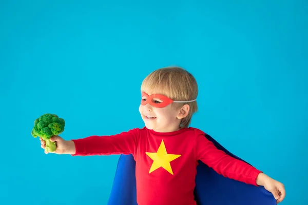 Superhéros enfant tenant brocoli — Photo