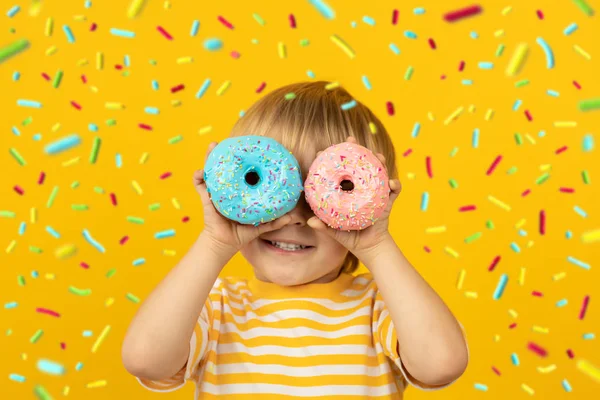 유약을 바른 도넛을 들고 있는 행복 한 어린이 — 스톡 사진