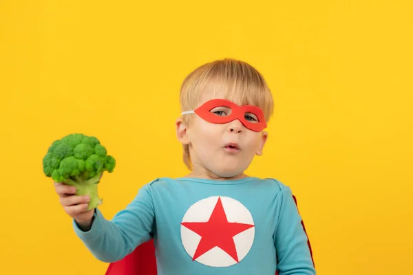Superhrdina dítě drží brokolici — Stock fotografie