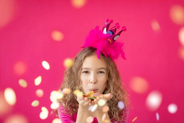 분홍색 빵집에 콘 페티를 불어 넣는 멋진 소녀 — 스톡 사진