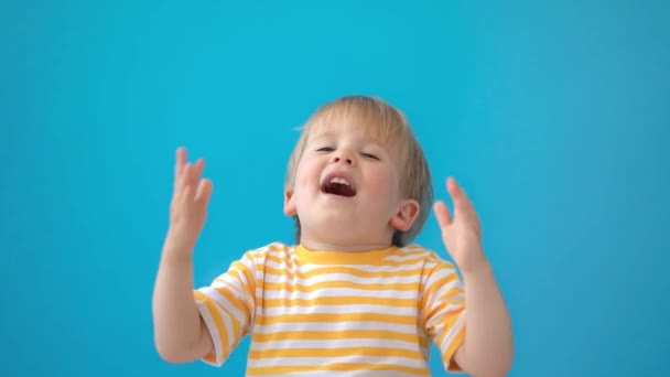 幸せな子供は楽しんでいます 青を背景に笑っている子供 夏休みと旅行のコンセプト スローモーション — ストック動画