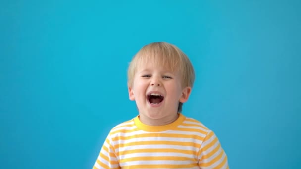 快乐的孩子有乐趣 小孩在蓝色的背景下大笑 暑假和旅行的概念 慢动作 — 图库视频影像