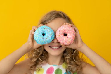 Mutlu çocuk jöleli donut tutuyor.