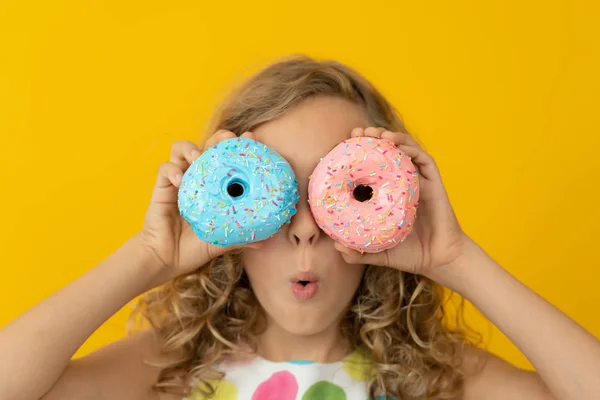 Щаслива дитина тримає глазурований пончик — стокове фото