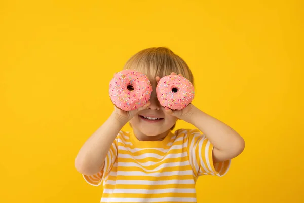Щаслива дитина тримає глазурований пончик — стокове фото