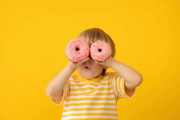 Criança feliz segurando donut envidraçado — Fotografia de Stock