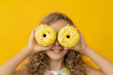 Mutlu çocuk jöleli donut tutuyor.