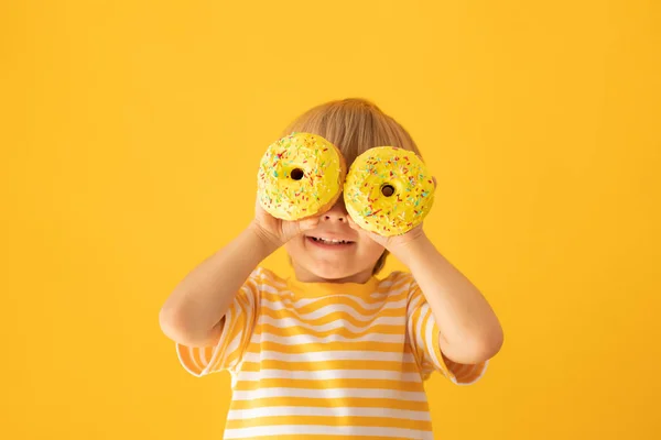 Glückliches Kind mit glasiertem Donut — Stockfoto