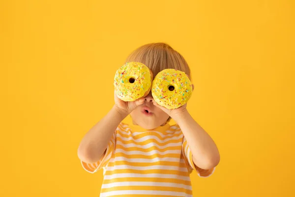 Glückliches Kind mit glasiertem Donut — Stockfoto