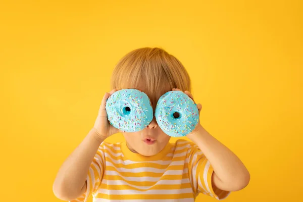 Glückliches Kind mit glasiertem Donut — Stockfoto