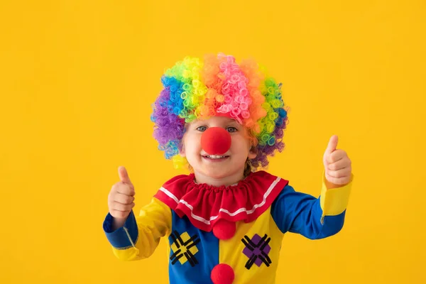 Grappig kind clown spelen tegen gele achtergrond — Stockfoto