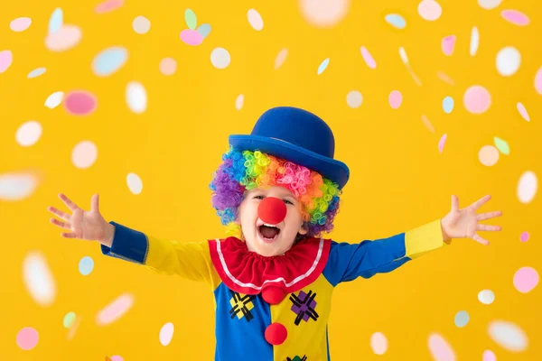 Funny kid clown playing against yellow background — Stock Photo, Image