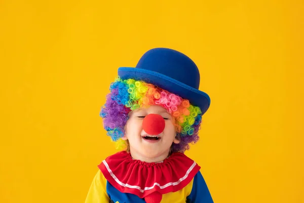 Buffo bambino clown giocare contro giallo sfondo — Foto Stock