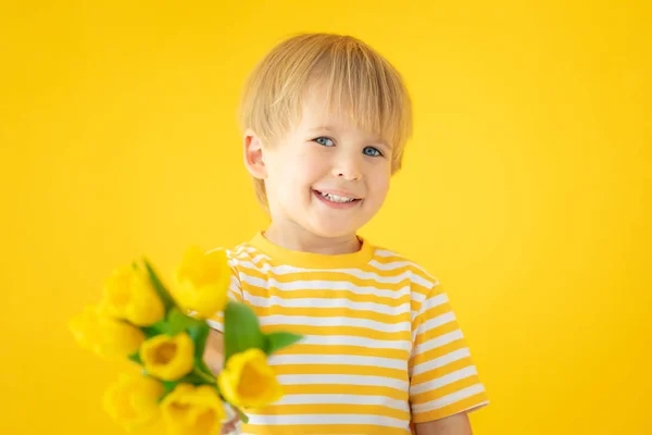 Happy child holding spring bouquet of flowers — Stok fotoğraf