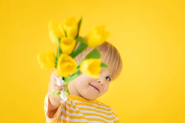 Ευτυχισμένο παιδί που κρατάει ανοιξιάτικο μπουκέτο λουλούδια — Φωτογραφία Αρχείου