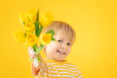 Happy child holding spring bouquet of flowers