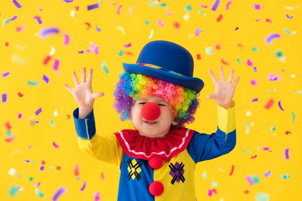 Funny kid clown playing against yellow background — Stock Photo, Image