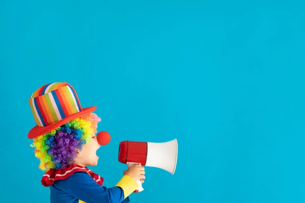 Funny kid clown shouting by megaphone — Zdjęcie stockowe