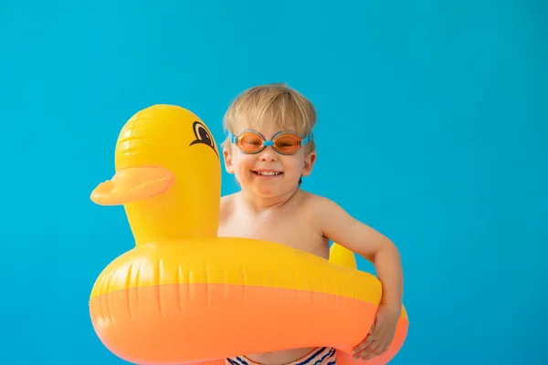带着蓝色背景的黄色橡胶鸭的快乐孩子的画像 孩子们暑假过得很开心 梦想和想象的概念 — 图库照片